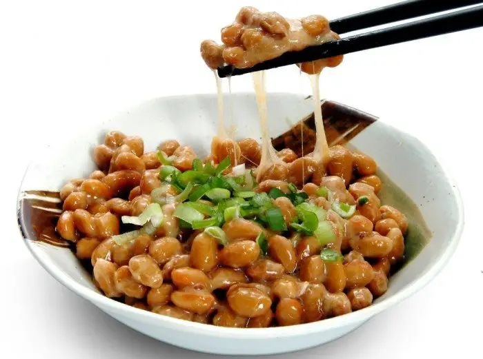 Natto, a soja fermentada japonesa Natto servido em tigela mostrando a textura viscosa da soja fermentada