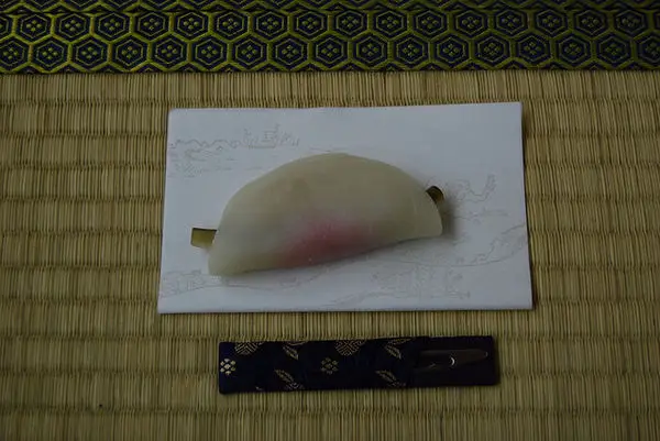 Hanabiramochi Hanabiramochi — kue mochi putih berbentuk kelopak bunga, diisi pasta kacang hijau manis, dihidangkan di atas daun