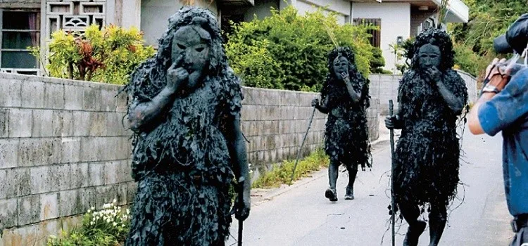 Maskierte Pantu-Figuren ziehen beim Fest in Miyako auf Okinawa durch die Strassen, um böse Geister zu vertreiben und Häuser zu segnen