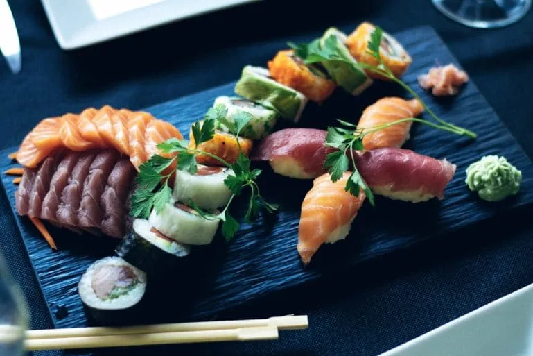 Técnicas de sushi em cursos de culinária japonesa Peças de sushi preparadas em bancada, mostrando cortes e montagem usados em aulas de culinária japonesa