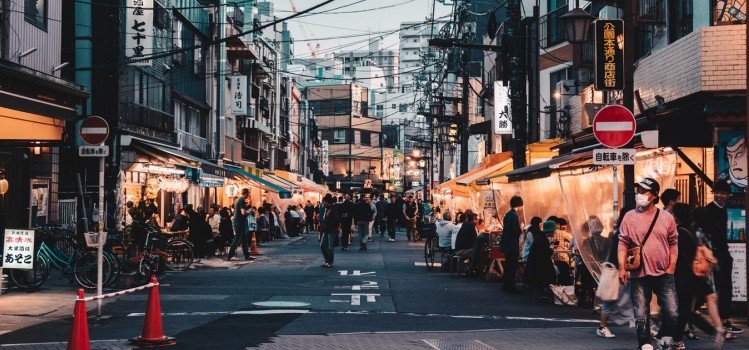 Rua movimentada no Japão com lojas e pedestres Rua japonesa movimentada com lojas, placas e pessoas caminhando