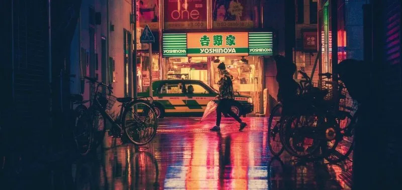 Rua iluminada no Japão durante a noite, lembrando imersão cultural