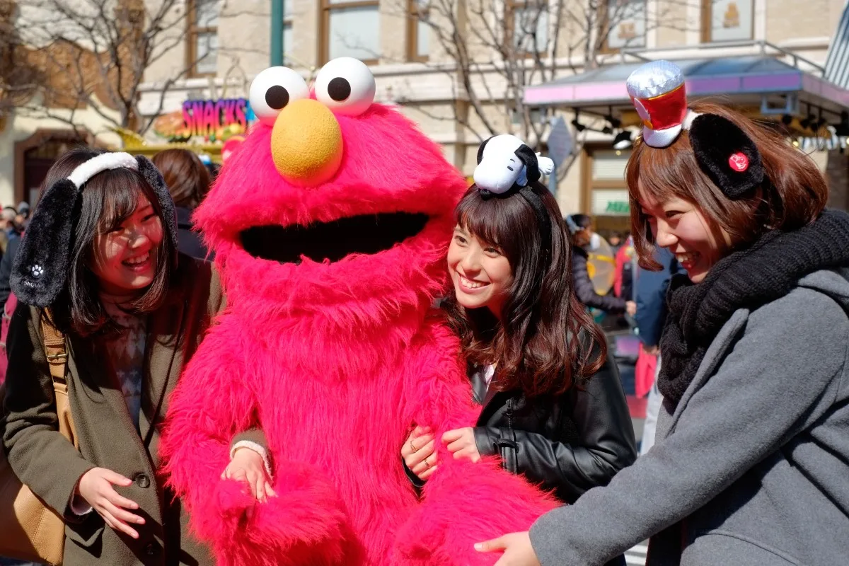 Happy asian girls take shot with Sesame Street Elmo in Universal Studios Japan (USJ), Osaka, Japan