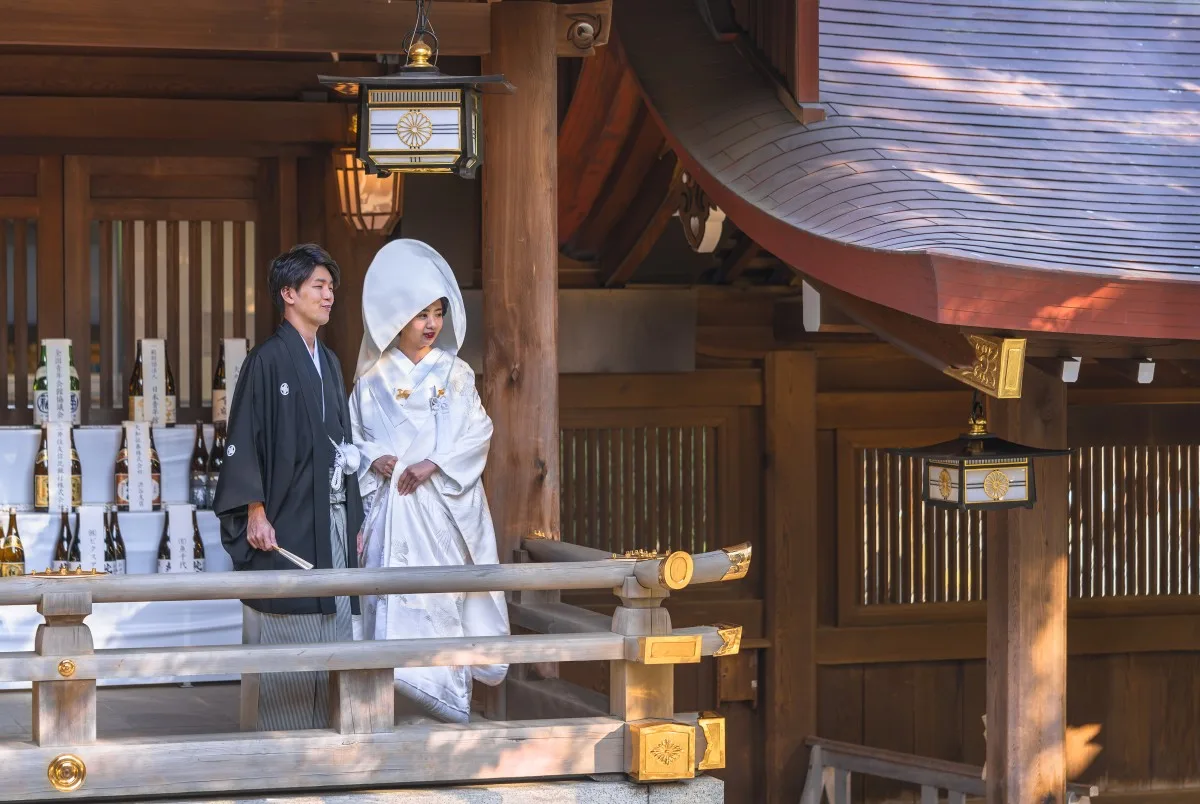tokyo, japan - october 10 2020: Traditional Japanese shinto wedding of a couple in black haori kimono and white shiromuku under a lantern ornated of the imperial coat of arm in the Meiji Shrine.