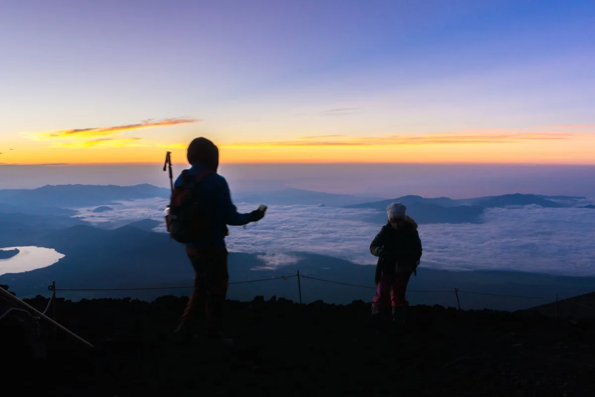 Hikers gather during sunrise on the Mt. Fuji summit.