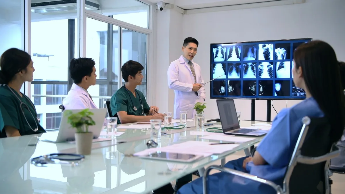 Equipe médica em reunião discutindo cuidados e tecnologias aplicadas à saúde