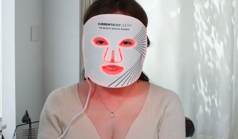 일본 미용 클리닉에서 시술 중 컨트롤 장치에 연결된 LED 얼굴 마스크를 착용한 여성