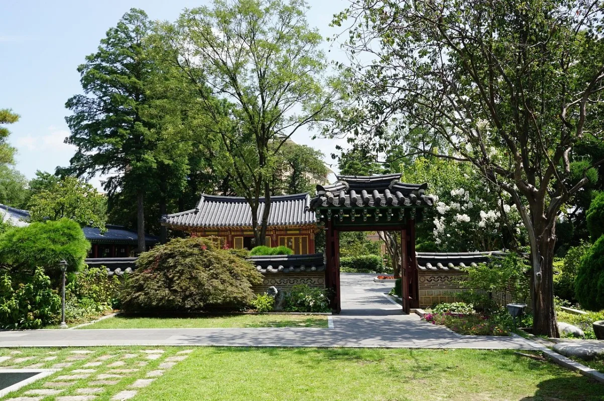 Traditional Korean temple rooflines and old trees in a quiet rural setting